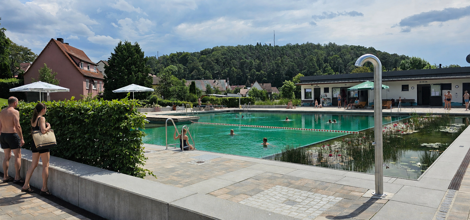 Blick aufs Becken im Naturfreibad mit Menschen