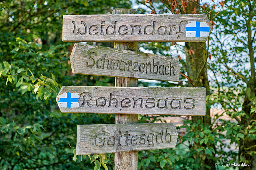 4 Wanderschilder übereinander aus Holz frontal fotografiert