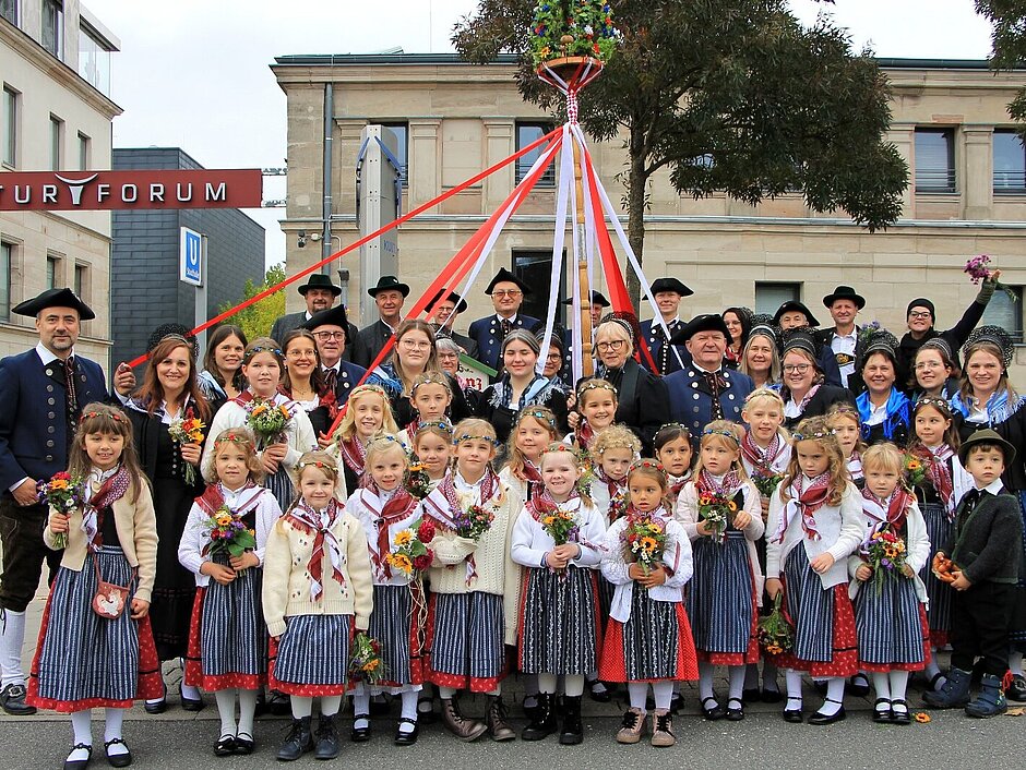 Eine Gruppe von Menschenmit Kindern und Erwachsenen in traditioneller Tracht 