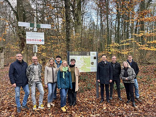 Eine Gruppe Menschen vor einer Wandertafel