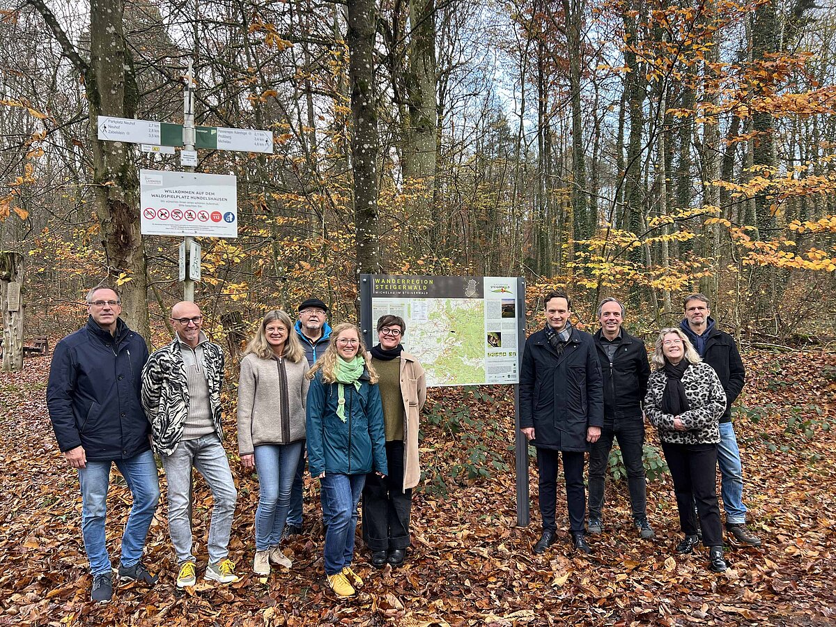 Eine Gruppe Menschen vor einer Wandertafel