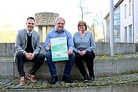 Drei Personen zeigen den Titel des Wegweisers Psychische Gesundheit