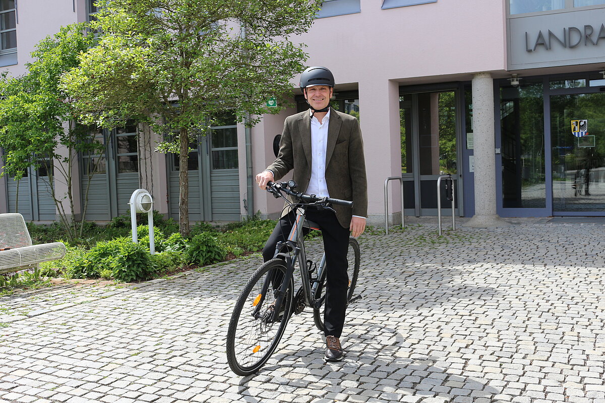 Landrat auf Fahrrad vor dem Landratsamt