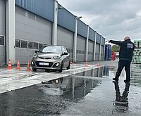 Auto, das auf nasser Folie beim Verkehrssicherheitstraining fährt