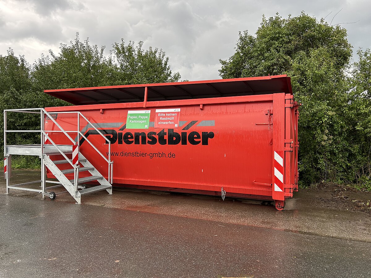 großer Papiercontainer auf der Zufahrtsstraße