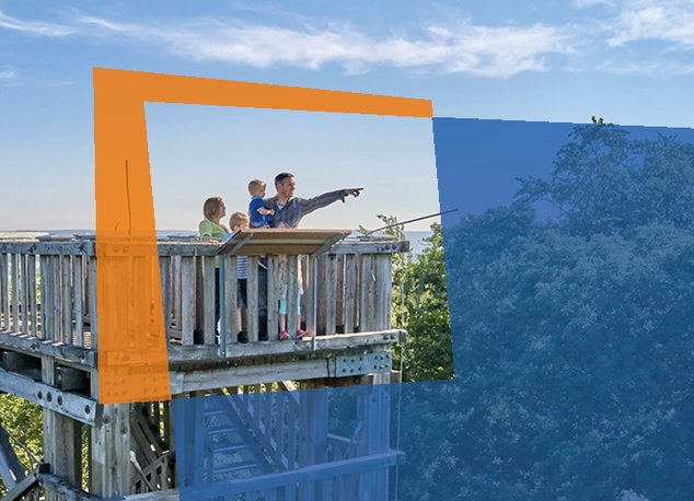 Ein Rahmen hebt eine Familie hervor, die auf einem Aussichtsturm in die Ferne blickt.