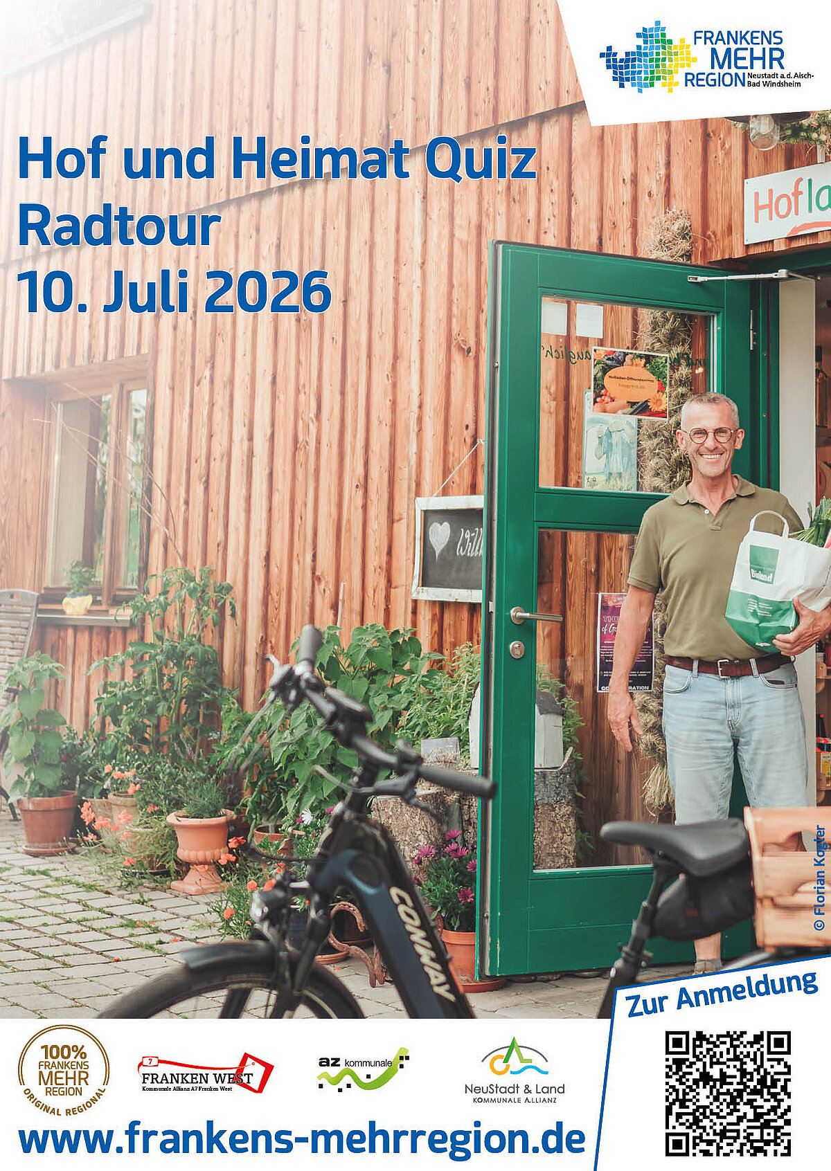 Ein Mittelalter Mann kommt aus einem Hofladen mit grüner Türe und Holz an der Fassade mit einer vollgepackten Einkaufstüte und läuft auf sein Rad zu. 