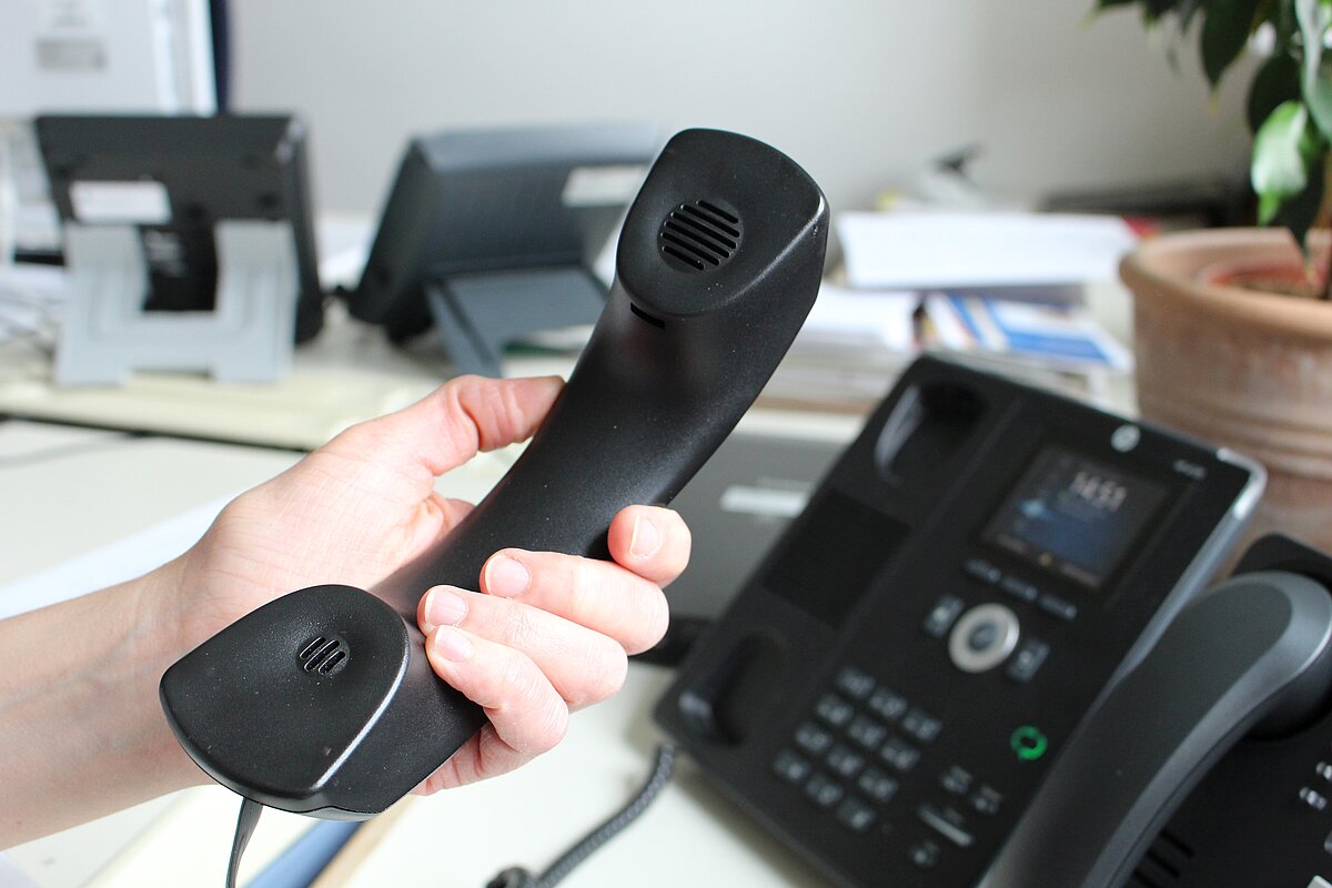 ein Telefonhörer wird von einem Telefonapparat im Landratsamt abgehoben