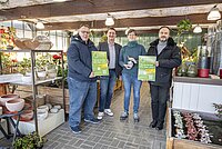 Plakat wird im Blumenladen überreicht