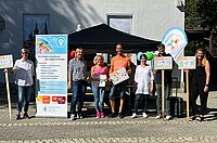 Gruppe von Personen steht vor Stand