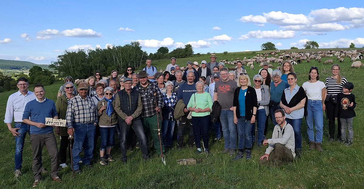 Gruppenfoto auf einer Weise mit Schafen im Hintergrund