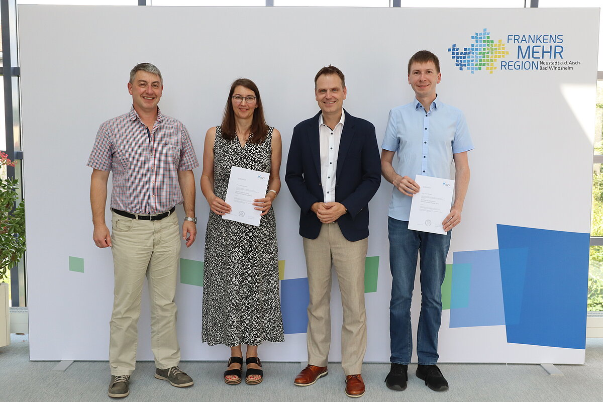 Vier Personen vor der Fotowand mit dem Logo "Frankens Mehrregion"