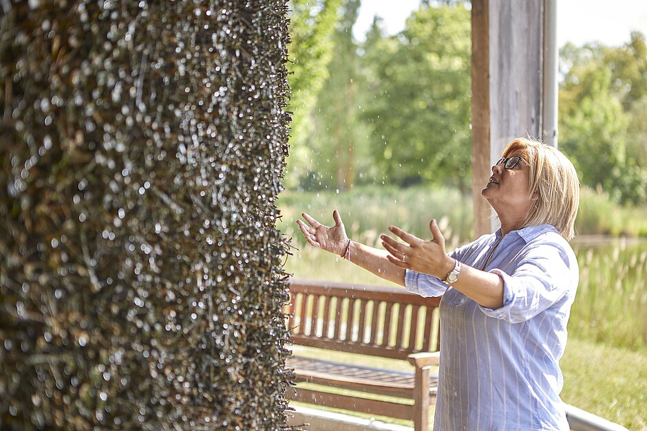 Eine Frau steht im Gradierwerk und atmet durch