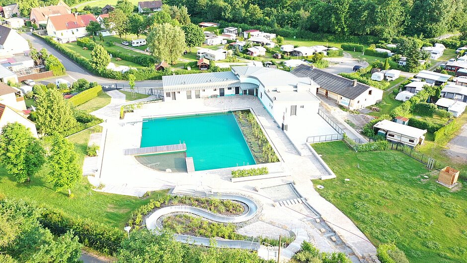 Luftaufnahme des Steigerwald Mineralbad, Wasser leuchtet türkis und ist umringt von Grünflächen