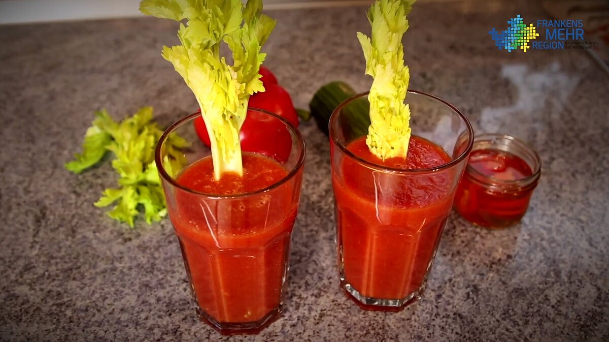 Zwei Gläser mit Tomatensmoothie und Stangensellerie