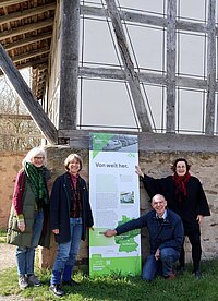 Vier Personen vor einem Schil im Fränkischen Freilandmuseum 