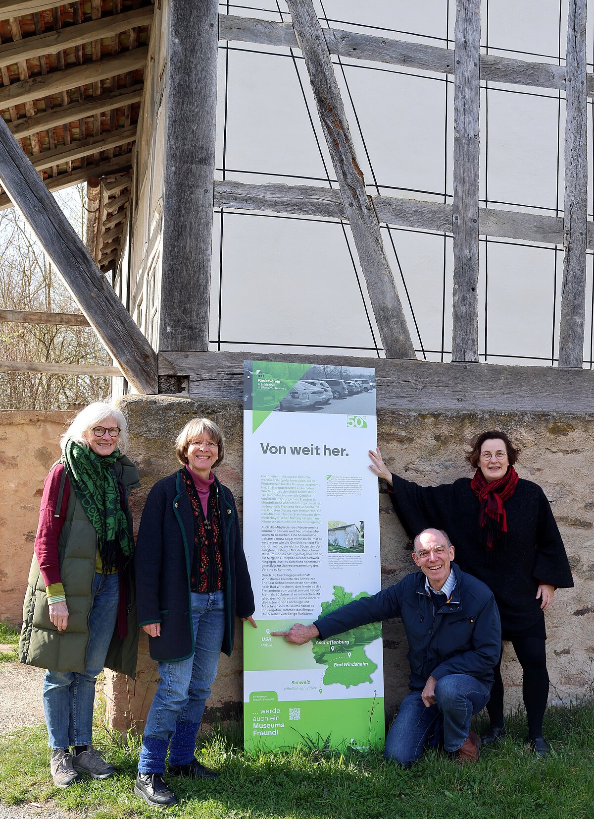 Vier Personen vor einem Schil im Fränkischen Freilandmuseum