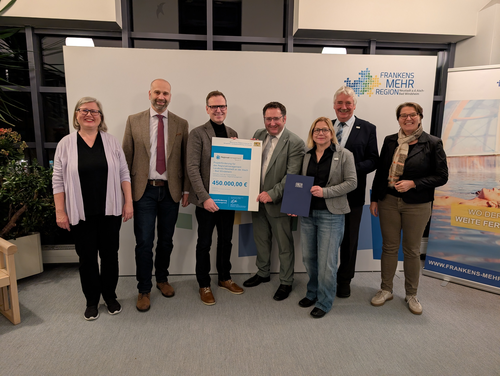 Bayerns Wirtschaftsstaatssekretär Tobias Gotthardt (4. v. l.) bei der Übergabe des Förderbescheids.