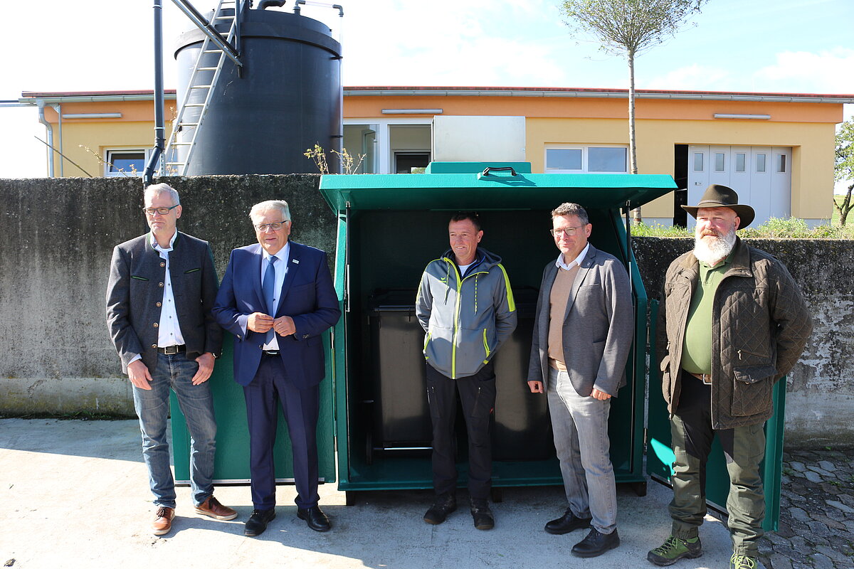 Gruppe von Personen steht vor dem Kühlcontainer
