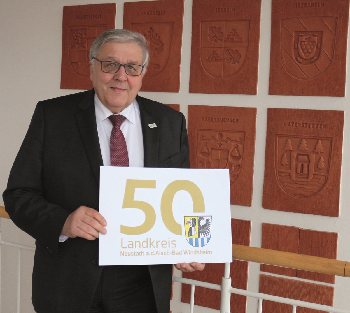 Landrat Helmut Weiß zeigt das ausgedruckte Logo 50 Jahre Landkreis