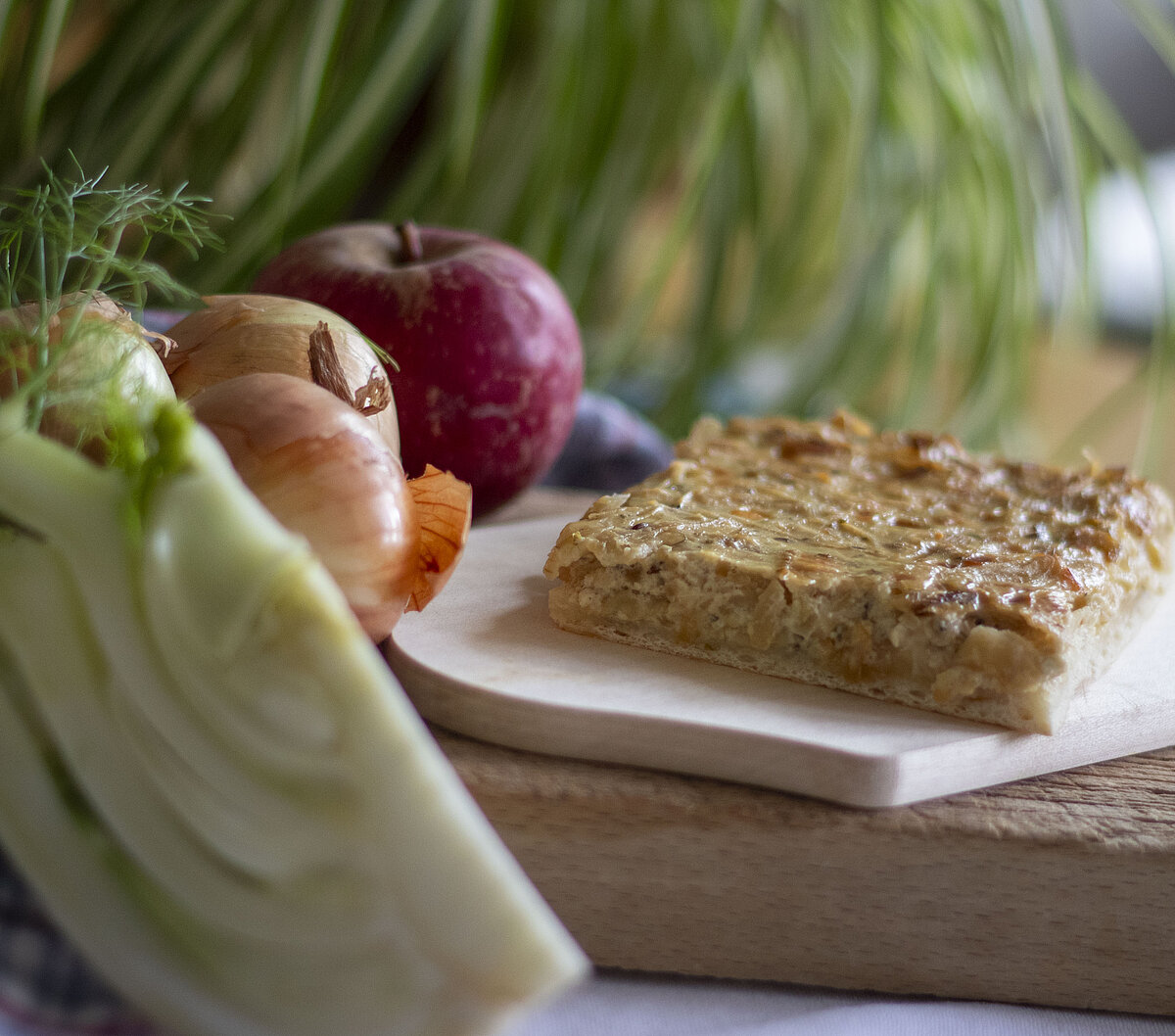 Zwiebelkuchen mit Fenchel, Zwiebeln und Äpfeln daneben